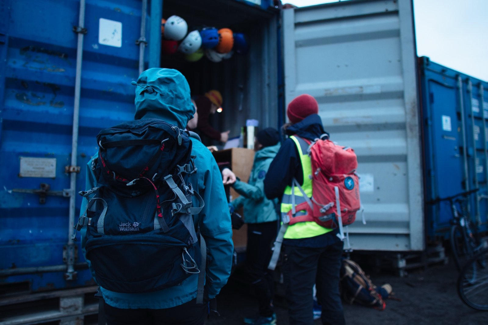 Field crew in winter gear loading equipment from blue containers