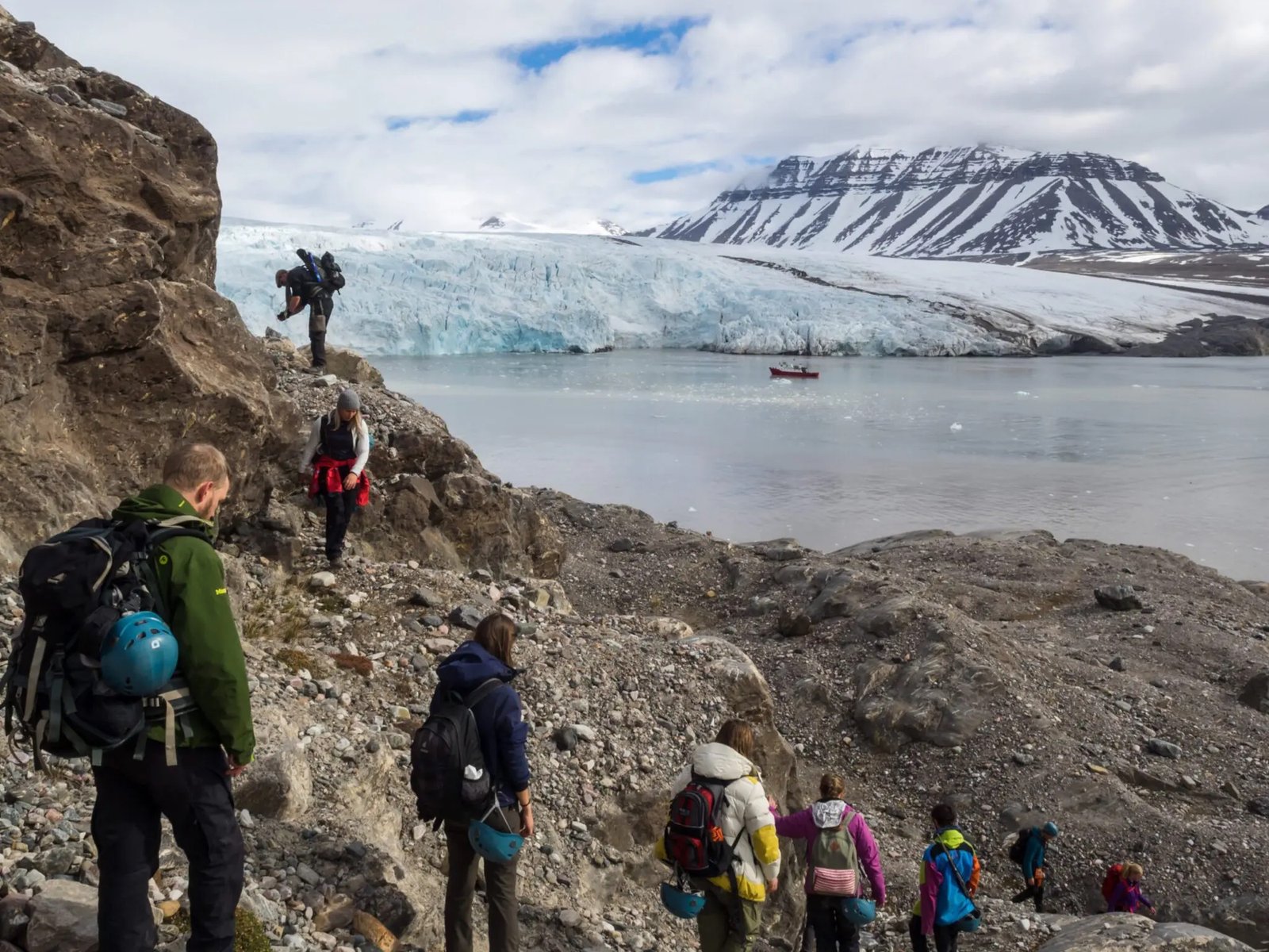 Students with backpacks on a ridge above a glacier front in Svalbard